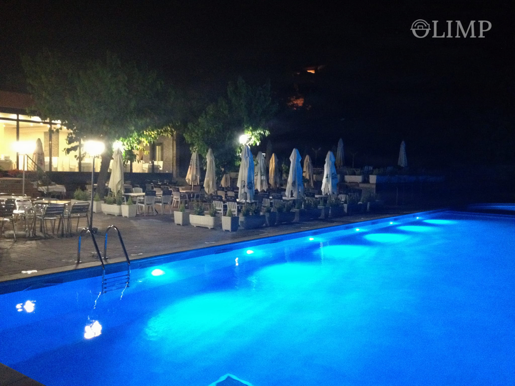 Piscina iluminada de noche en el complejo
