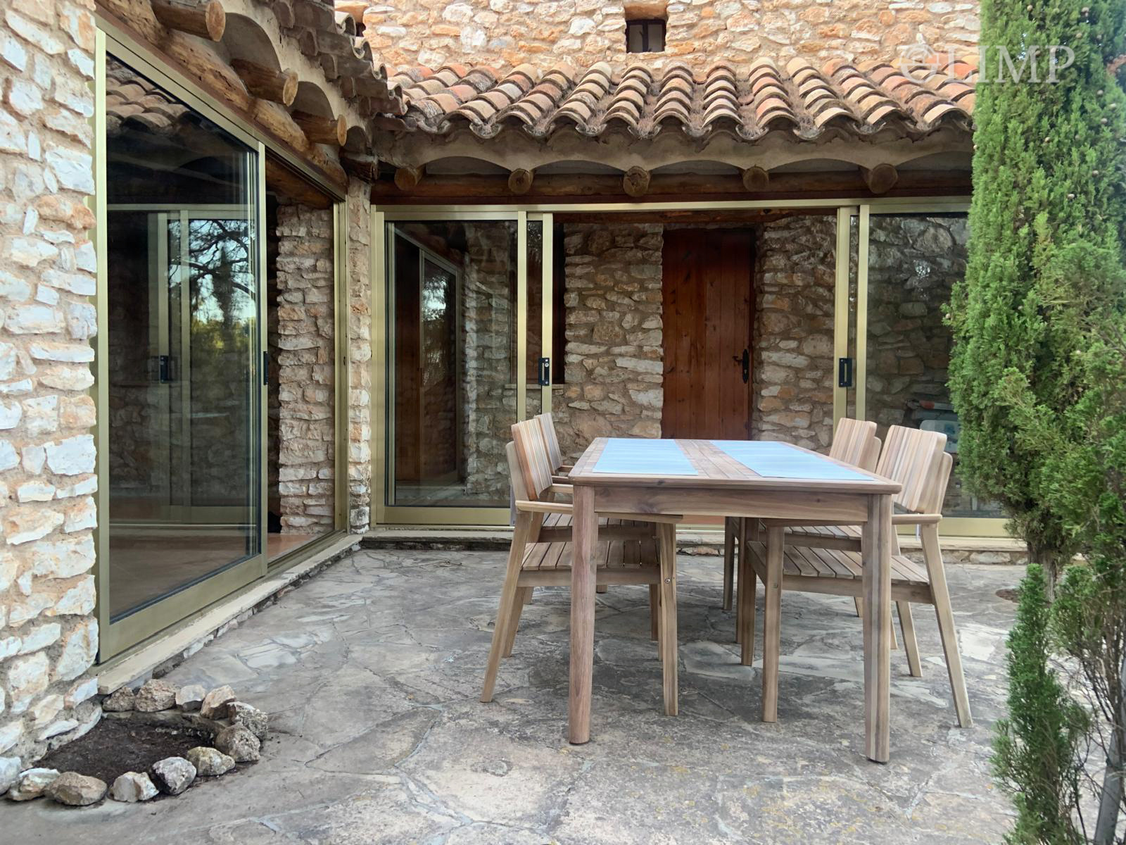 Terraza exterior con mesa junto al jardín