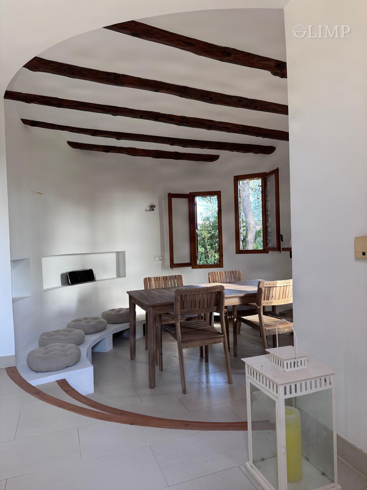 Salón con cocina abierta y vigas de madera