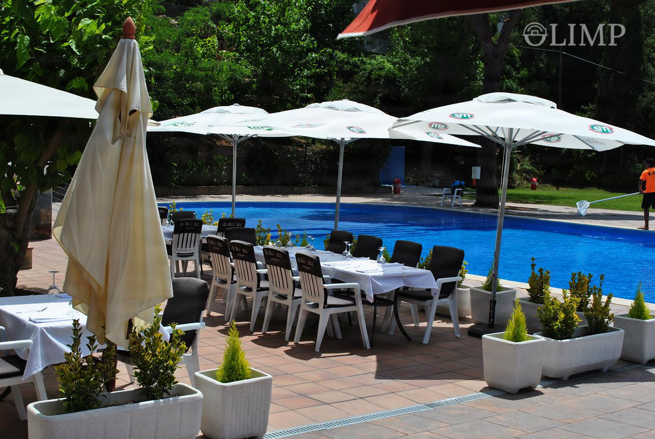 Terraza de piscina con tumbonas y sombrillas